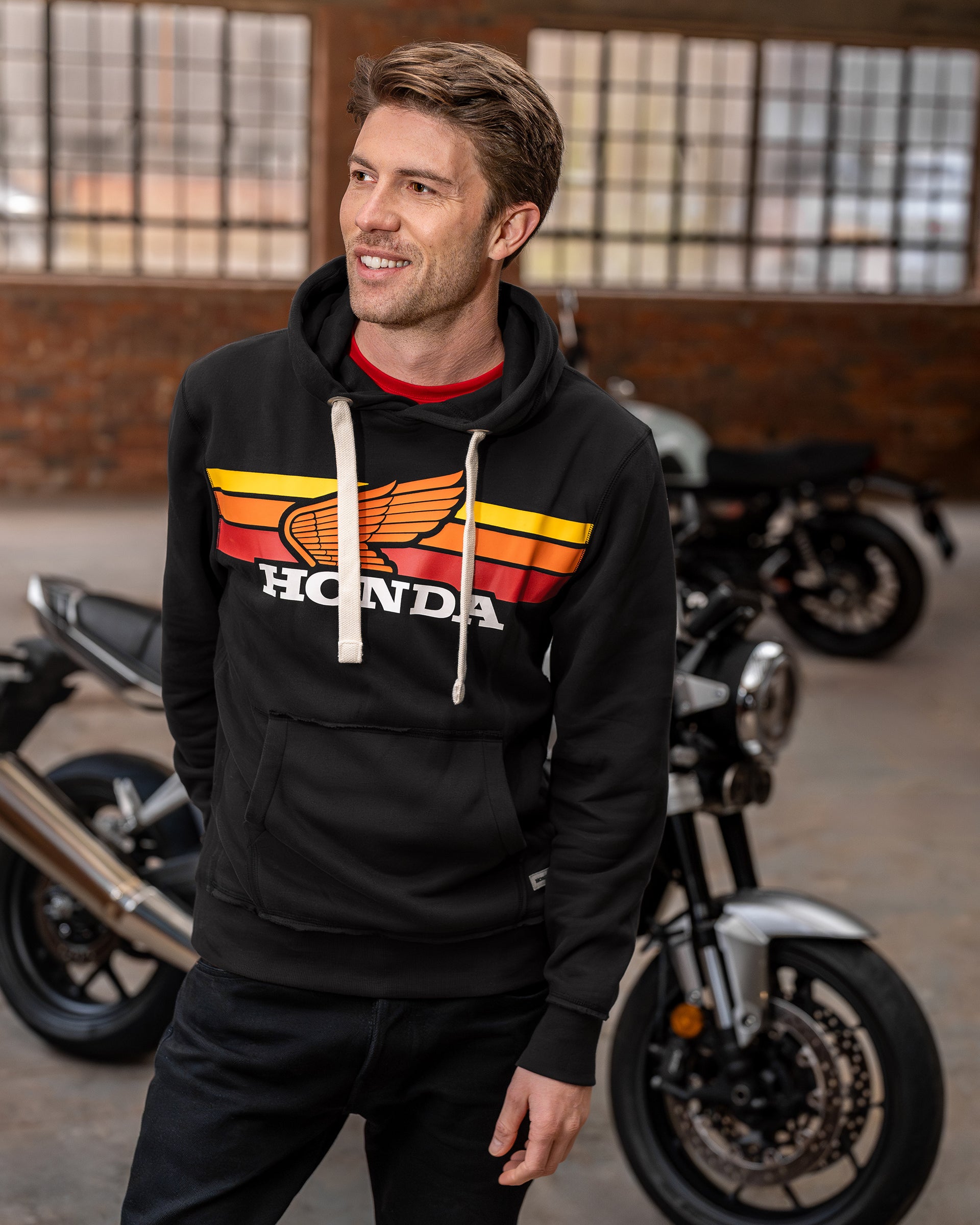 Honda Sunset Hoodie Schwarz, von einer Person getragen.