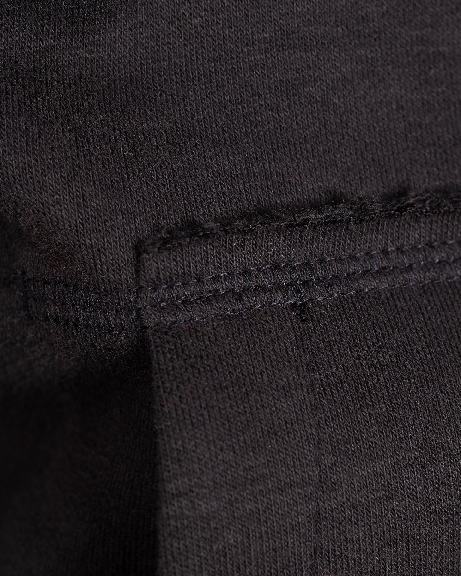 Nahaufnahme der Nahtführung und Kängurutasche am schwarzen Sunset Hoodie.