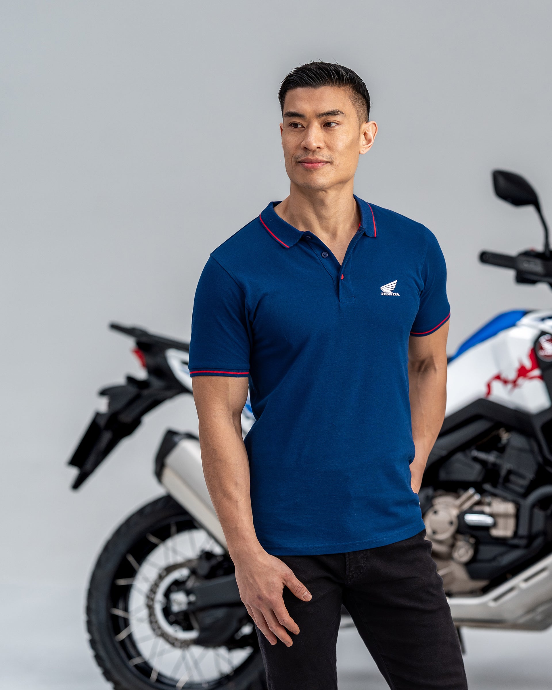 Honda Poloshirt Blau, von einer Person getragen.